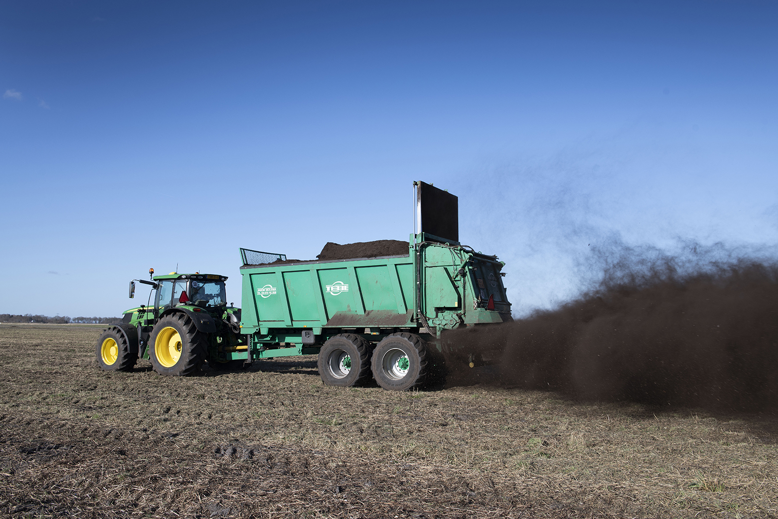 Het strooien van compost. - Foto: Mark Pasveer